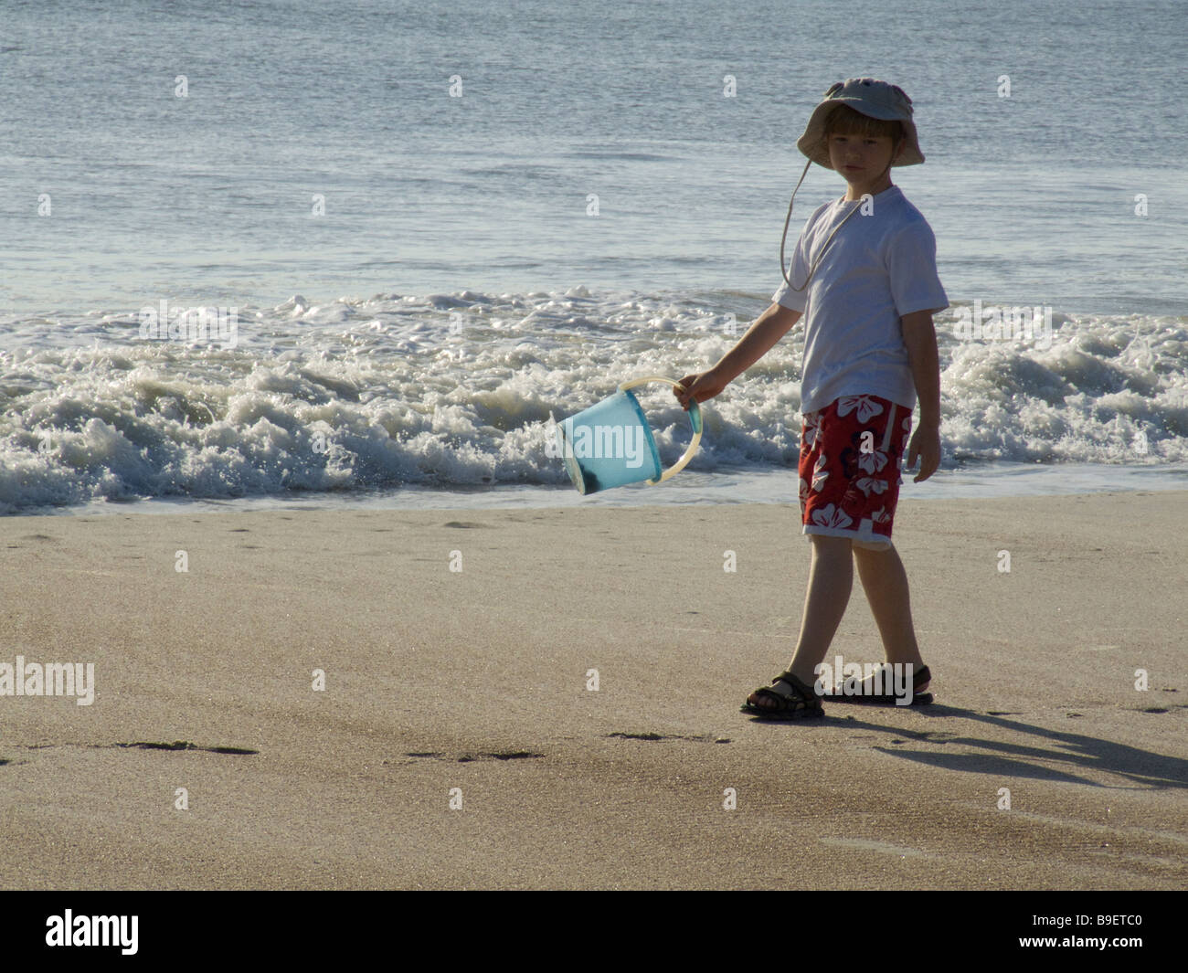 Boy on beach avec bouleverse le jeu près de vagues de l'océan Banque D'Images