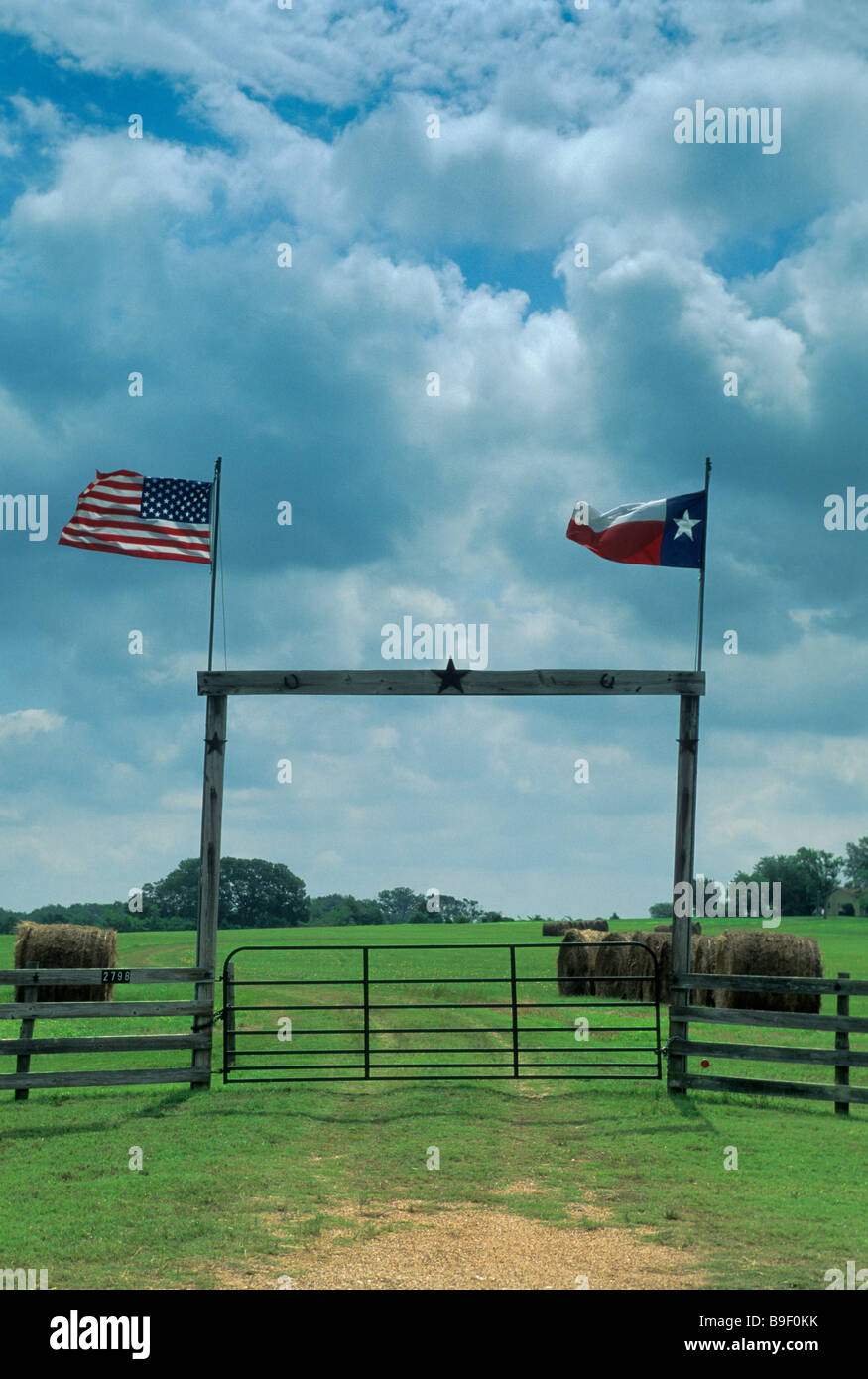 Ranch bois gate avec TX et drapeaux américains sur TX 90 l'autoroute près de Anderson Grimes County Texas USA Banque D'Images