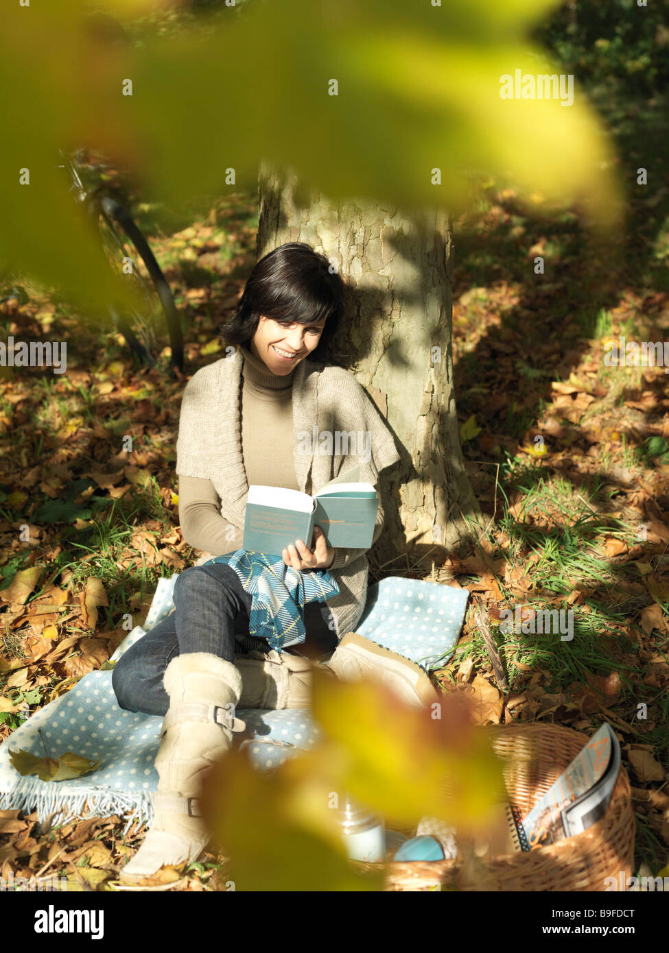 High angle view of young woman reading book sous ombre d'arbre Banque D'Images