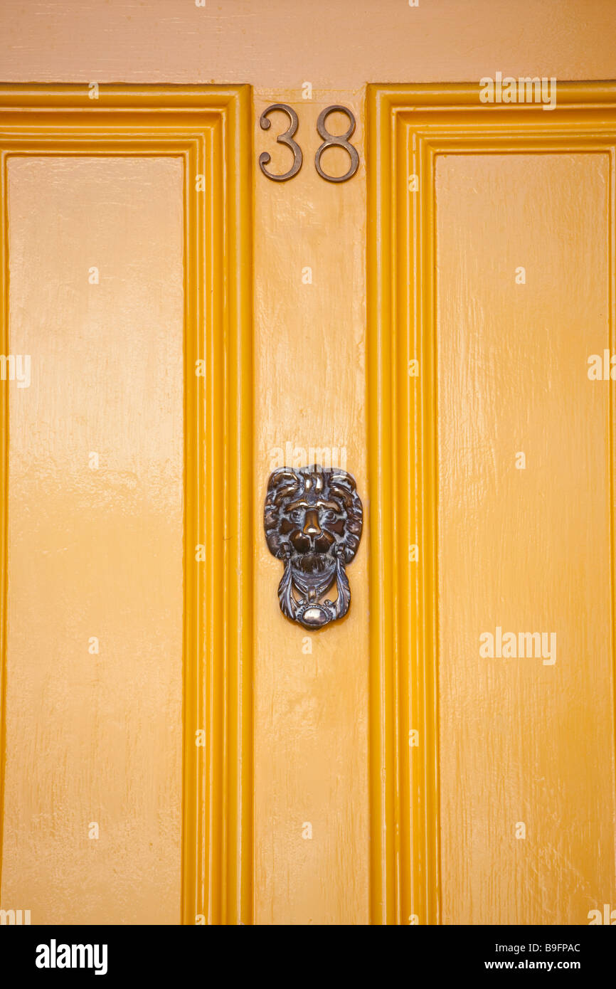 Peint en jaune vif, numéro de porte 38, avec tête de lion knocker Banque D'Images