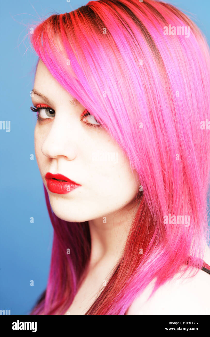 Jeune adolescent avec des cheveux de couleur rose vif à la côte sur à huis clos. Banque D'Images