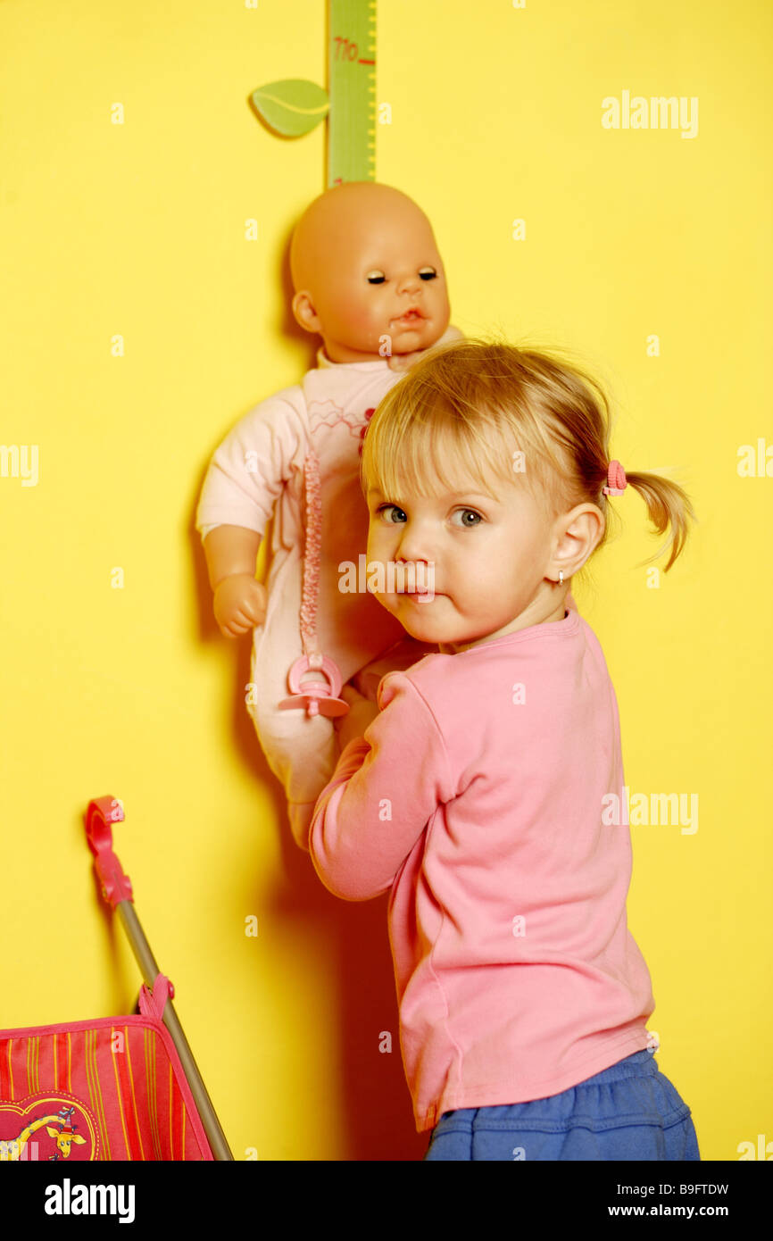 Girl blonde joue poupée jouet enfant enfance personnes détail baby-doll-âges préscolaire seule activité fun forestières à l'intérieur series Banque D'Images