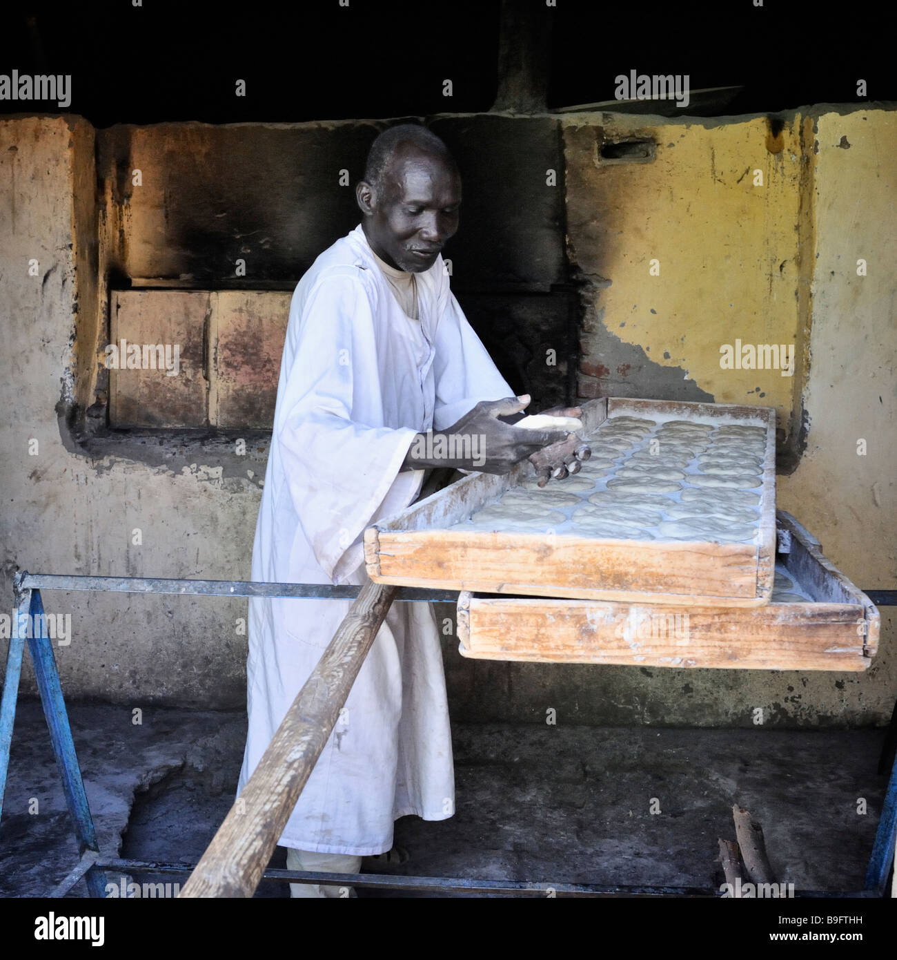 Baker, un vieil homme, la préparation de la pâte dans le grand plateau d'entrer dans un four traditionnel, dans petit village en Nubie, le nord du Soudan Banque D'Images