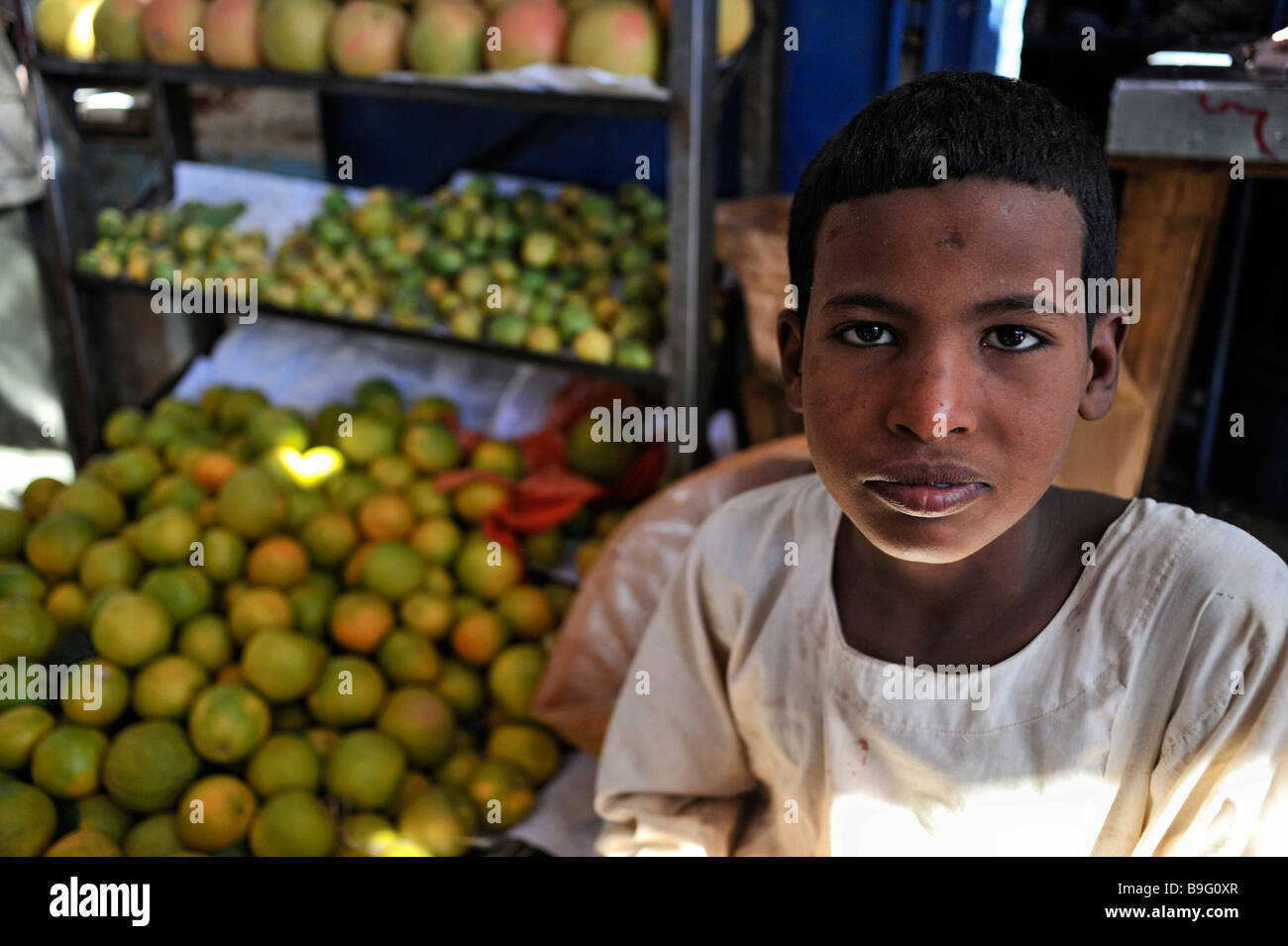 Jeune adolescent en face d'étal de fruits dans la ville de Debba, le nord du Soudan, Afrique Banque D'Images