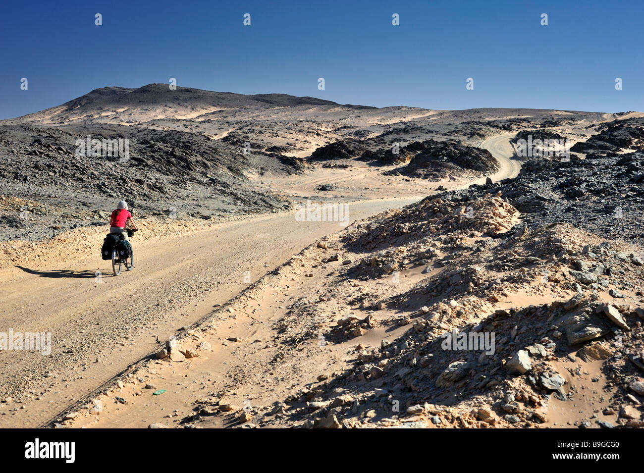 Cycliste féminin de l'ouest dans la région de désert de Nubie, le nord du Soudan Banque D'Images