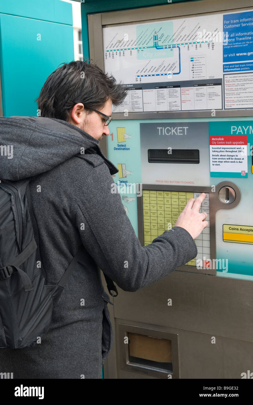L'homme d'acheter un ticket de la machine de ticket de tramway Manchester UK Banque D'Images