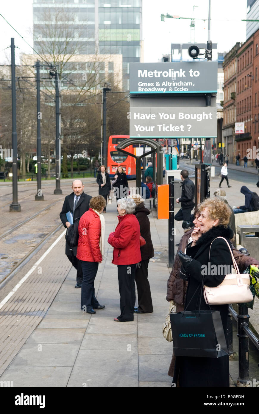 Les gens qui attendent sur la station de tram du centre-ville de Manchester UK Banque D'Images