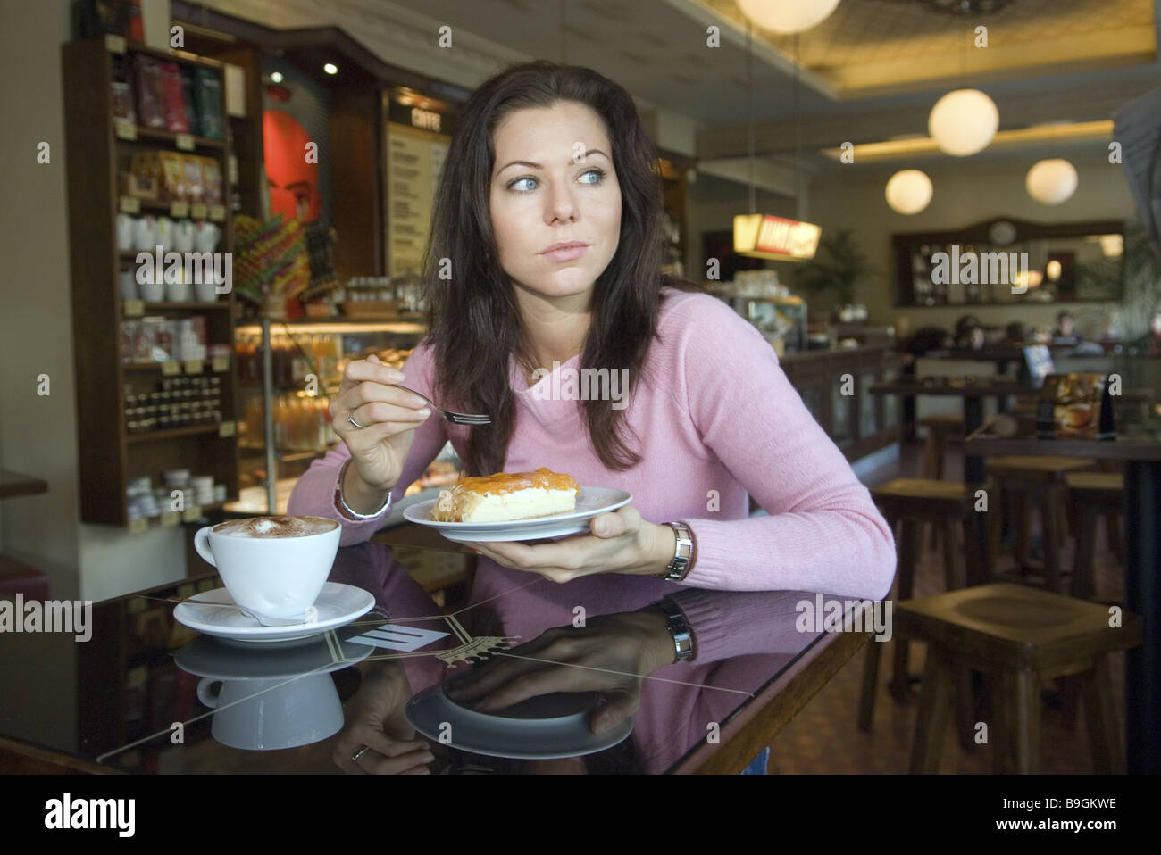 Stand-up femme jeune café cappuccino gâteaux boissons manger personnes série poil long cafe boire du café tasse de café Banque D'Images