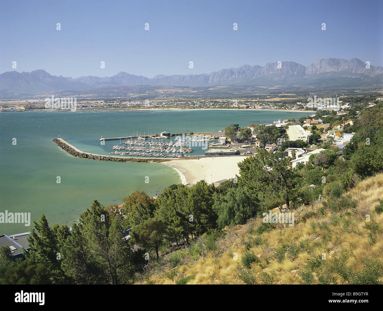 Gordon's Bay, Afrique du Sud - Aperçu de la ville-région de la côte de la ville portuaire de bâtiments maisons côte d'arrière-plan de la chaîne de montagne dock Banque D'Images