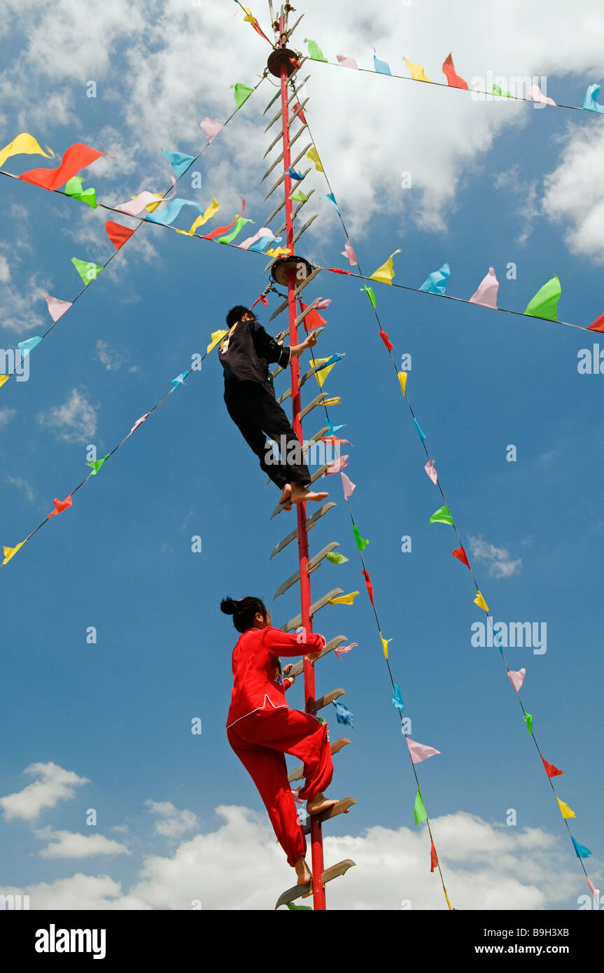 Les minorités ethniques de la Chine Pékin acrobates Parc escalade une échelle de lames Banque D'Images