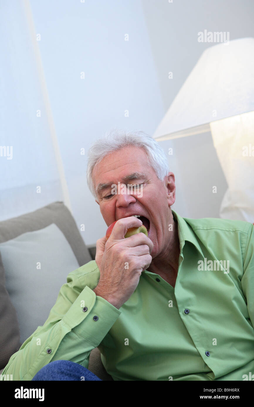 Siège canapé principal semi-alimentation apple série portrait des aînés retraités personnes l'homme aux cheveux blancs à pépins Fruits snack-moustiques OFF Banque D'Images