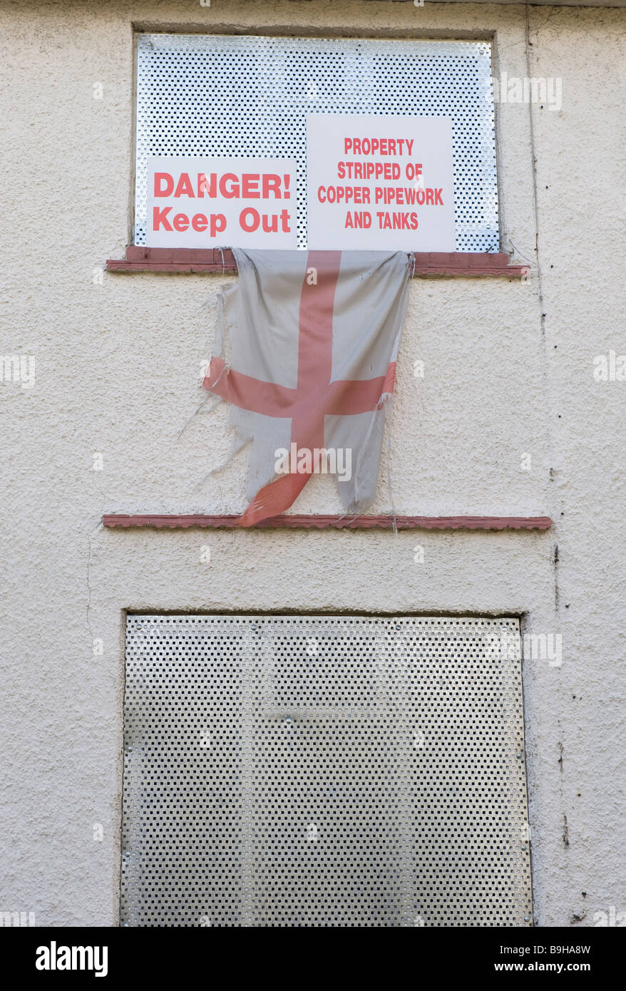 Un drapeau en lambeaux St George accrochée à une de maisons vides sur une ancienne cité près de Wolverhampton au les West Midlands Banque D'Images