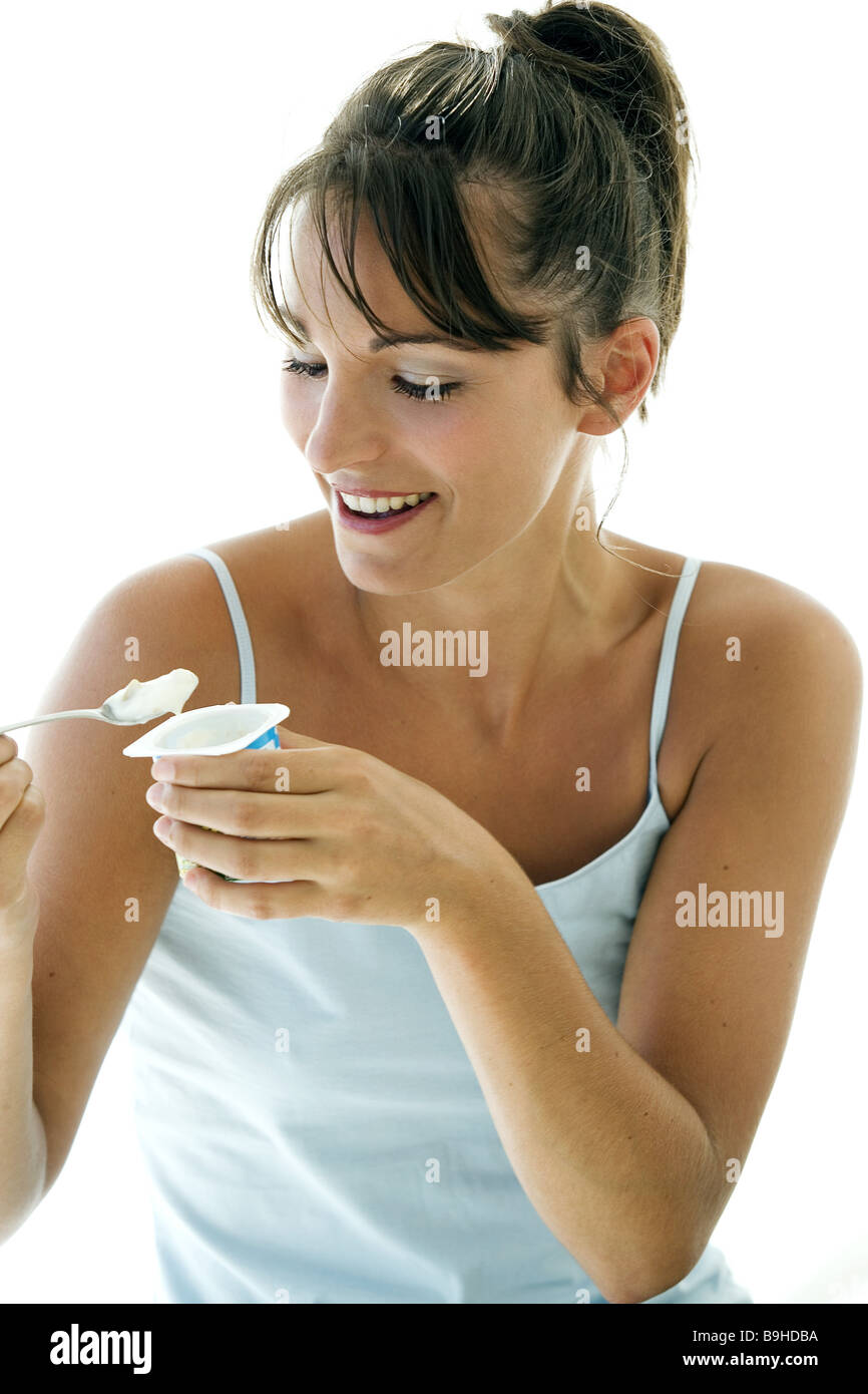 Siège femme jeune rire gaiement yaourt semi-manger de 20 à 30 ans portrait beauté bleu repas nutrition brunette woman clipping Banque D'Images