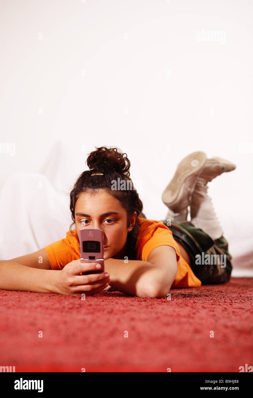Jeune femme au sérieux cell phone SMS reçoit lecture mensonge marbre personnes Fille 16-20 ans 20-30 ans tresse brune bottes lacées Banque D'Images