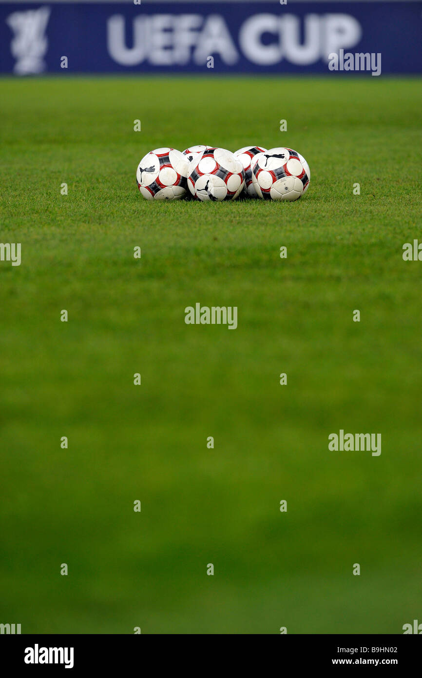 Ballons de football sur un terrain de football, en face de panneaux publicitaires avec le logo de l'UEFA-Cup Banque D'Images