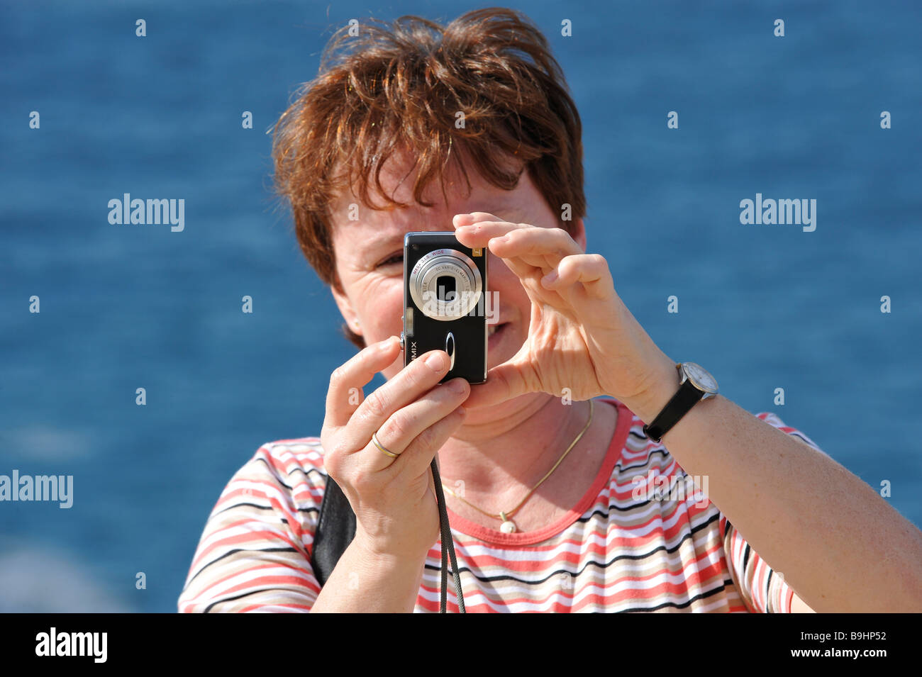 Femme de prendre une photo avec un appareil photo numérique Lumix Banque D'Images