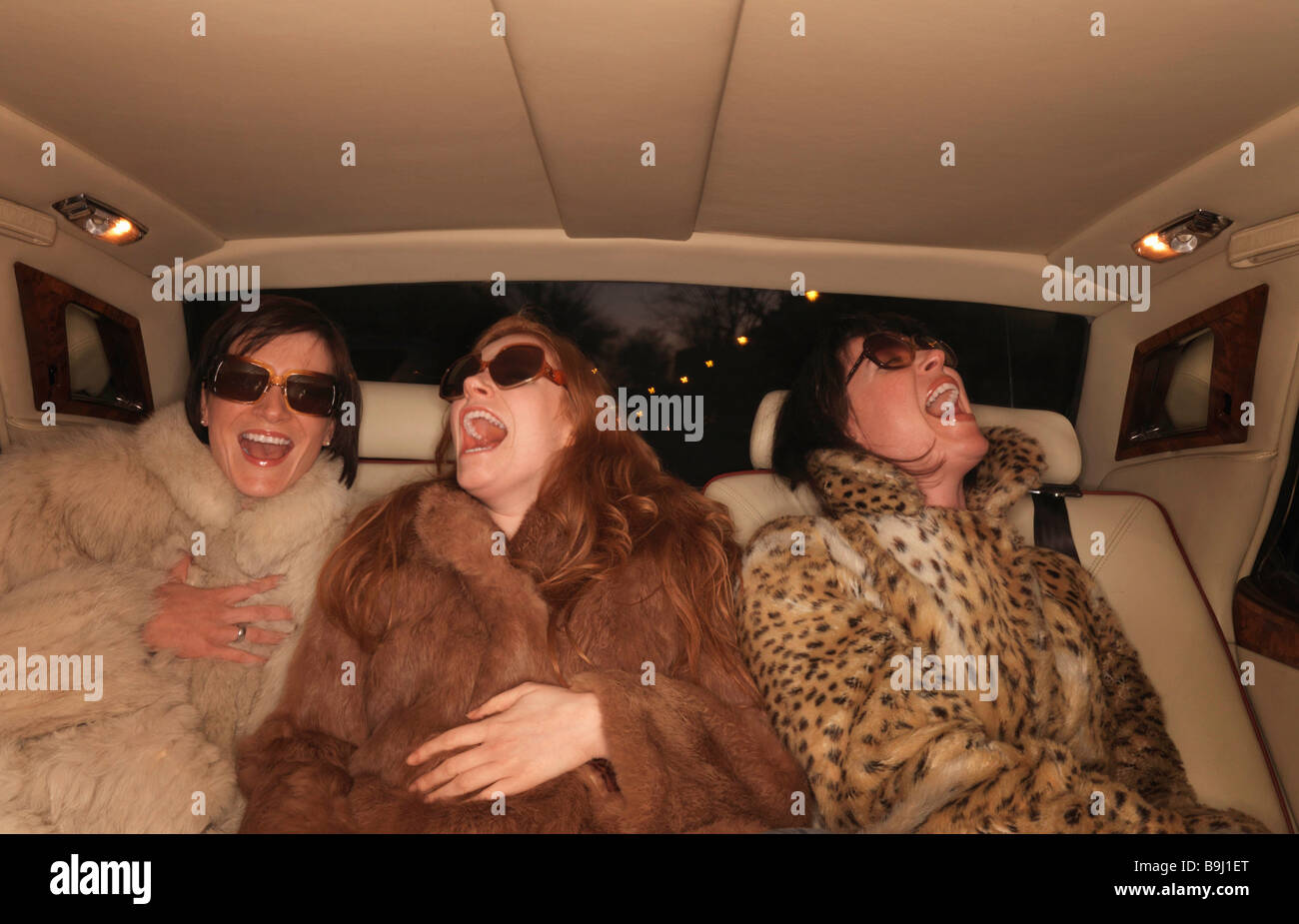 Trois femmes sur la banquette arrière de voiture de luxe Photo Stock - Alamy