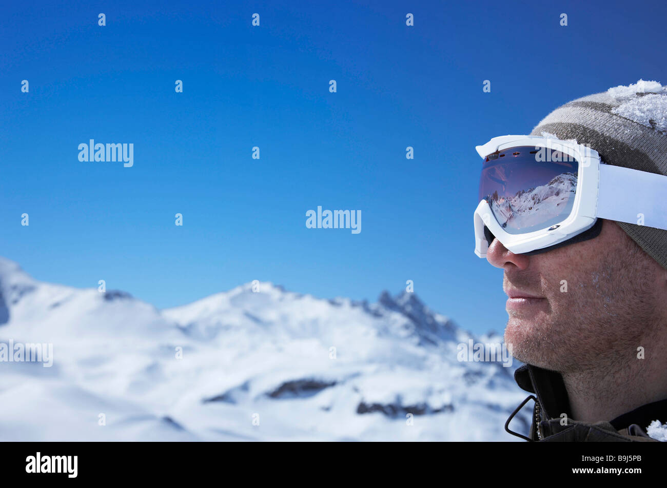 Gros Plan Des Lunettes De Ski D'un Homme Avec Le Reflet Des Montagnes  Enneigées