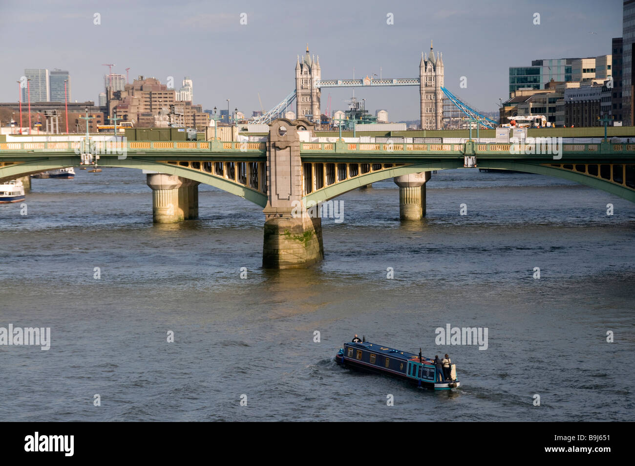 Bateau sur la Tamise, à venir jusqu'à Southwark Bridge, avec les deux tours du Tower Bridge en arrière-plan e Banque D'Images