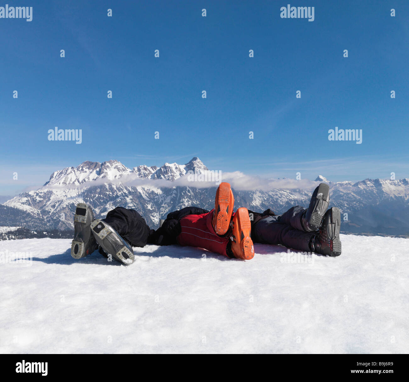3 hommes couchés dans la neige sur le sommet de la montagne Banque D'Images
