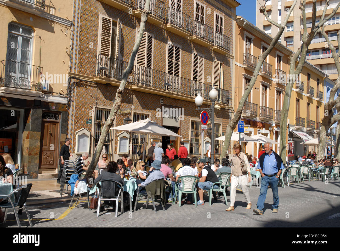 Couple walking passé encombré utdoor street cafe et restaurant, Denia, Alicante Province, Comunidad Valenciana, Espagne Banque D'Images