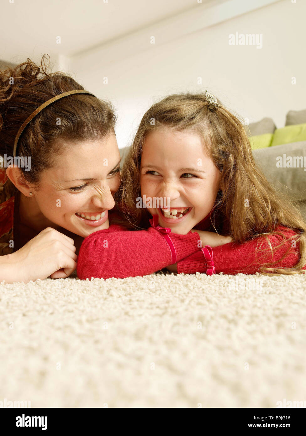 Mother and Daughter lying on rug Banque D'Images