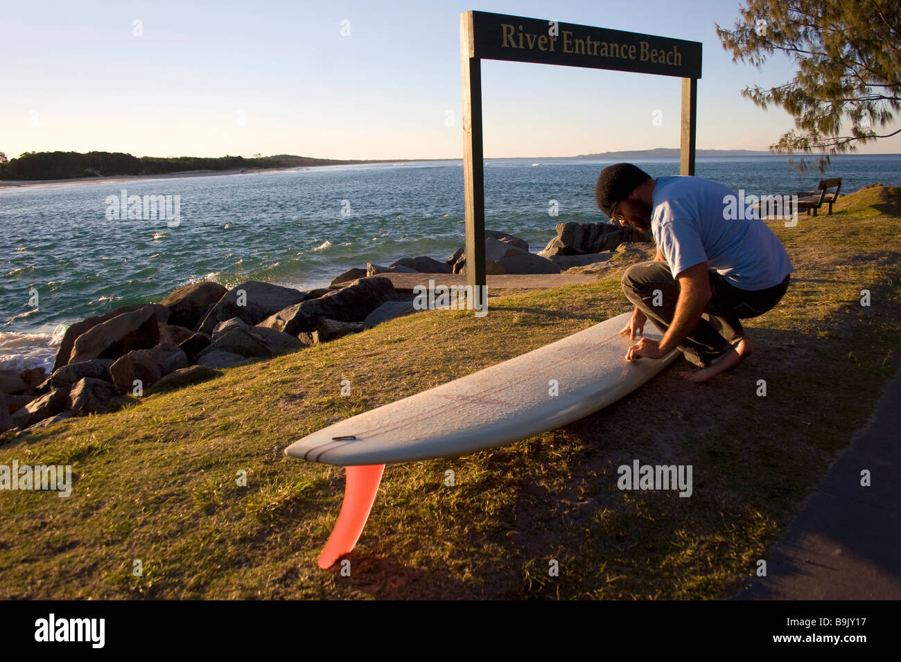 Les cires d'un surfer son conseil avant d'aller surfer à Noosa dans le Queensland, Australie Banque D'Images