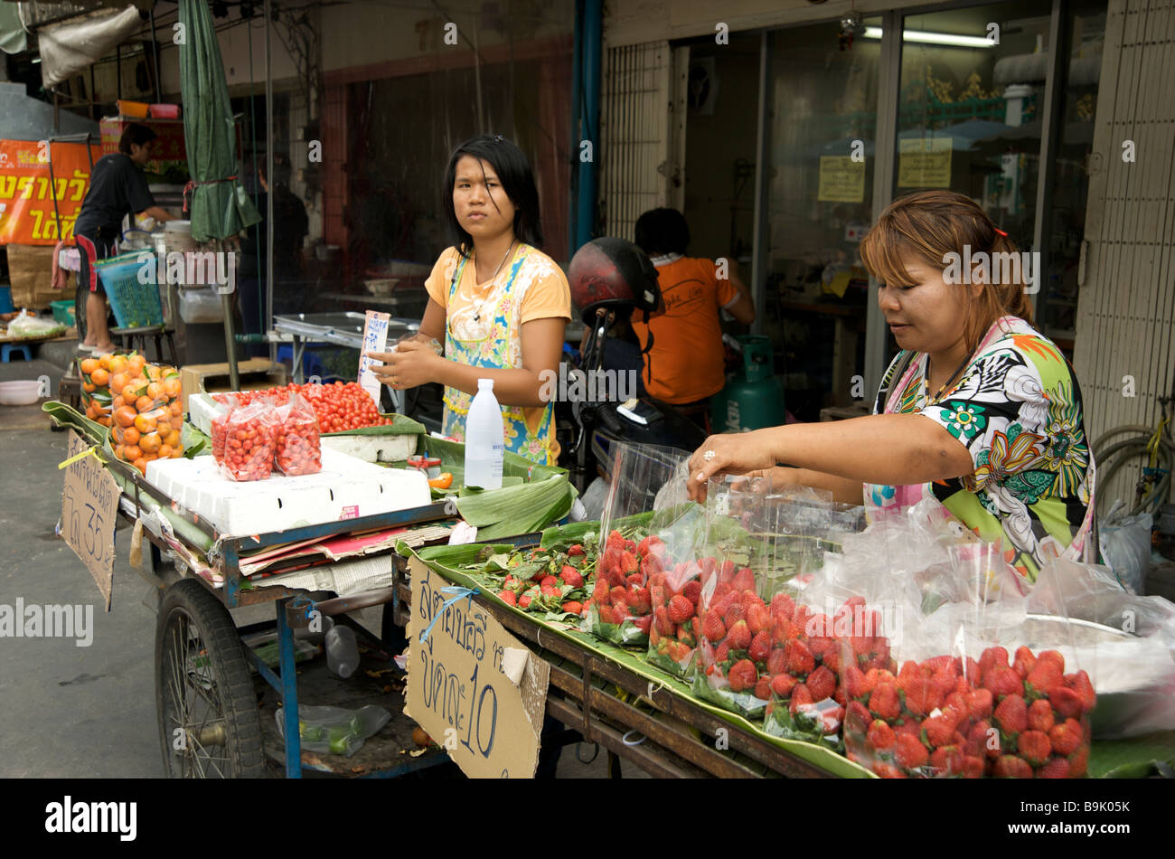 Deux femmes thaïlandaises vendant des fruits frais à leurs étals de rue à Bangkok Thaïlande Banque D'Images
