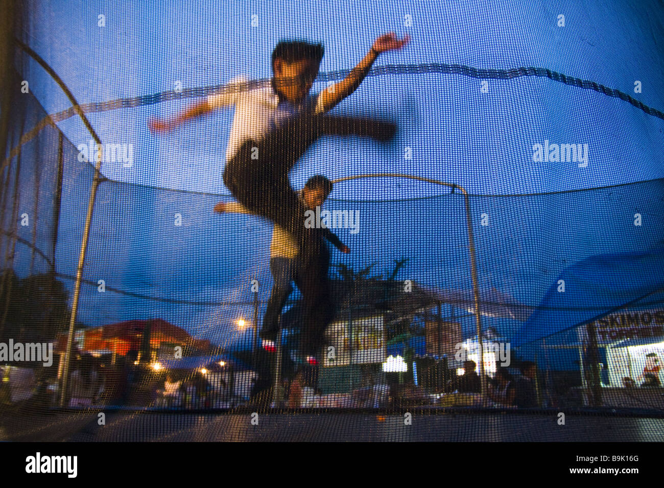 Des enfants jouent sur un trampoline dans Cuilapan, Oaxaca, Mexique. Banque D'Images