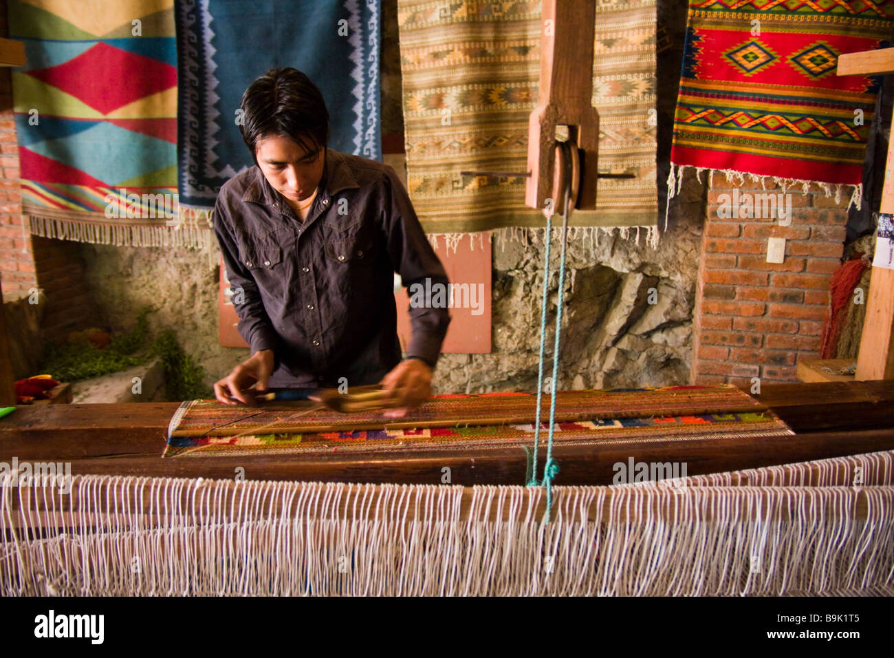 Un ouvrier tisse un tapis de laine à Teotitlan del Valle, Oaxaca, Mexique. Banque D'Images
