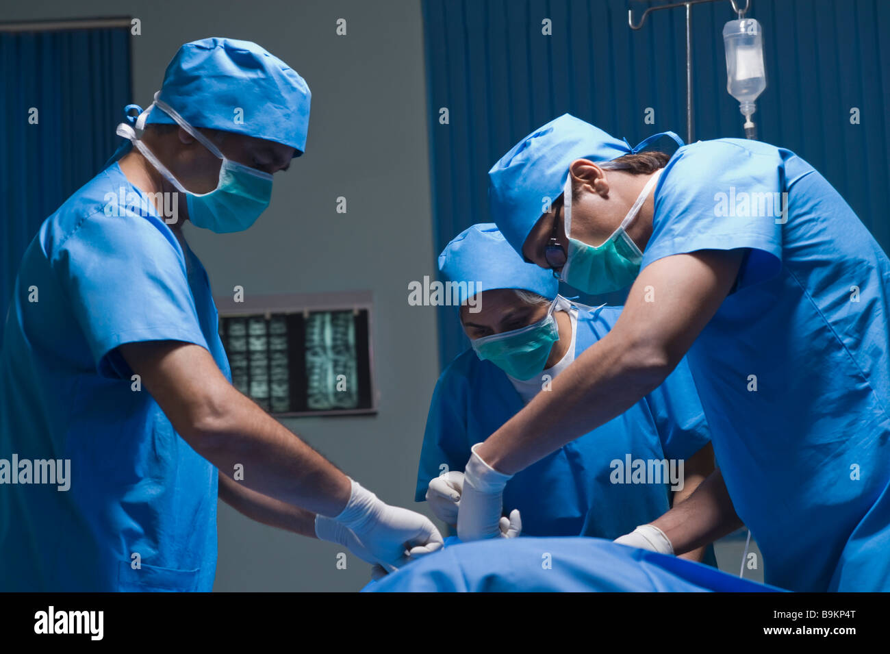 Trois chirurgiens d'effectuer une chirurgie dans une salle d'opération Banque D'Images