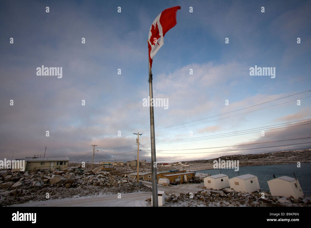 Drapeau du Canada qui flotte au-dessus de la ville côtière, de l'Arctique canadien, Canada Banque D'Images