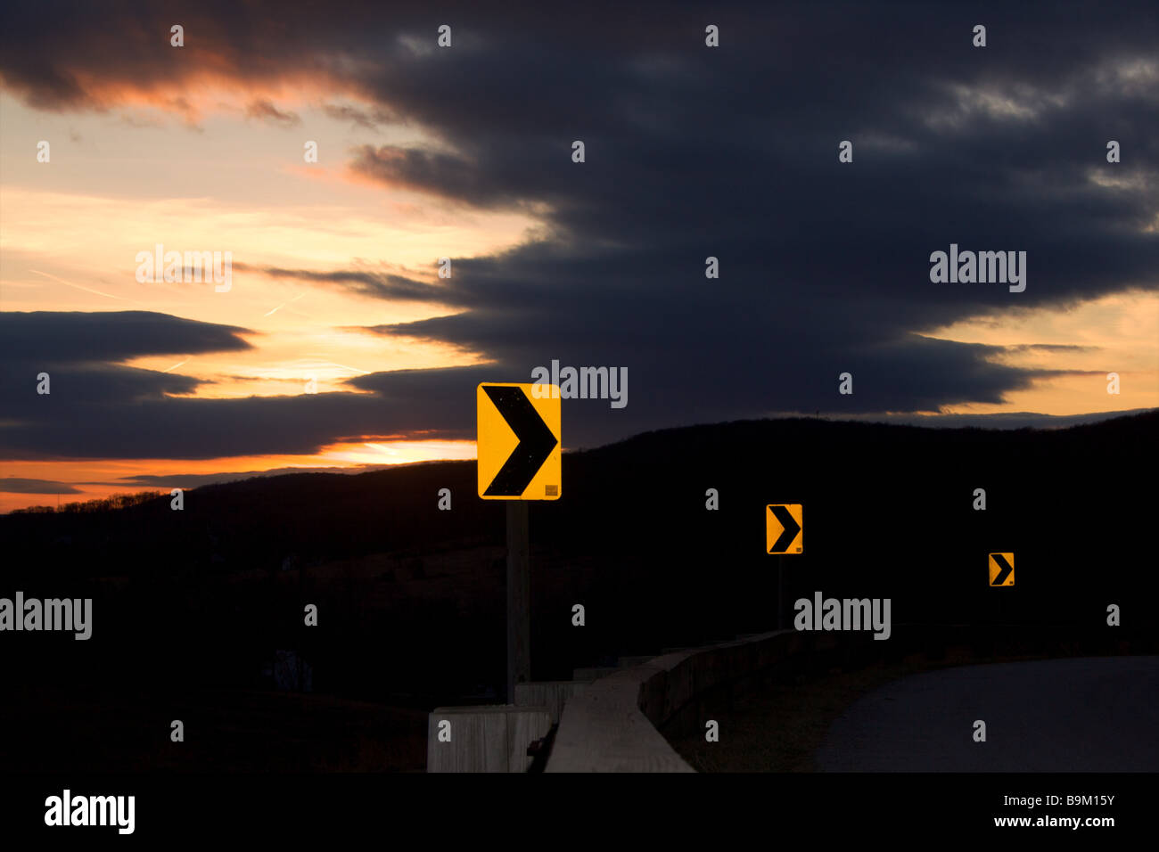 La signalisation routière un signal tourner de l'avant avec la lumière du soleil dans un ciel nuageux mais la distance Banque D'Images