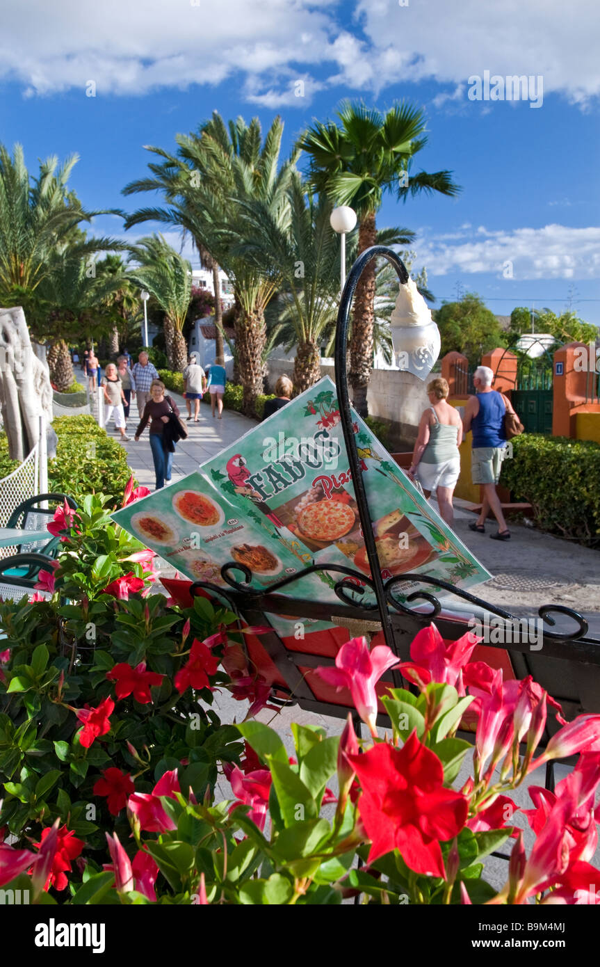 Piétonne ensoleillée promenade côtière à Los Cristianos avec restaurant typique en premier plan menu Tenerife Espagne Banque D'Images