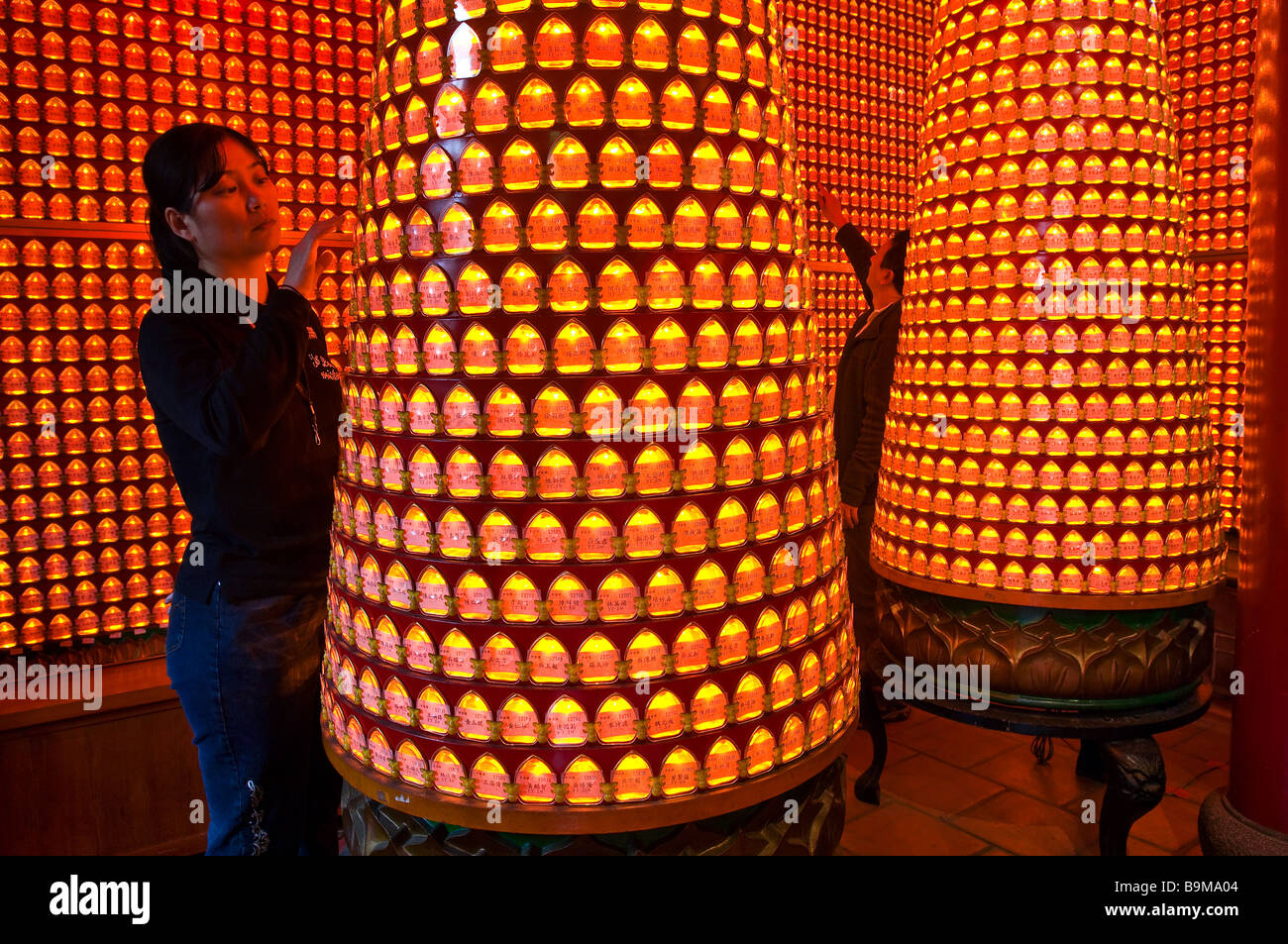 Taiwan, Taipei, Pao Bao An (un temple Taoïste), personne dans la chambre où les donateurs liste est représenté par petites lumières Banque D'Images