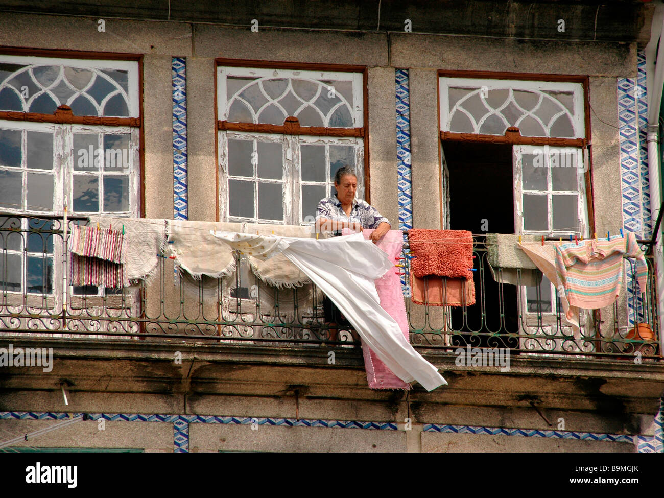 Une femme passe son temps à sécher les vêtements d'un Balcon. Télévision Porto - Portugal. Banque D'Images