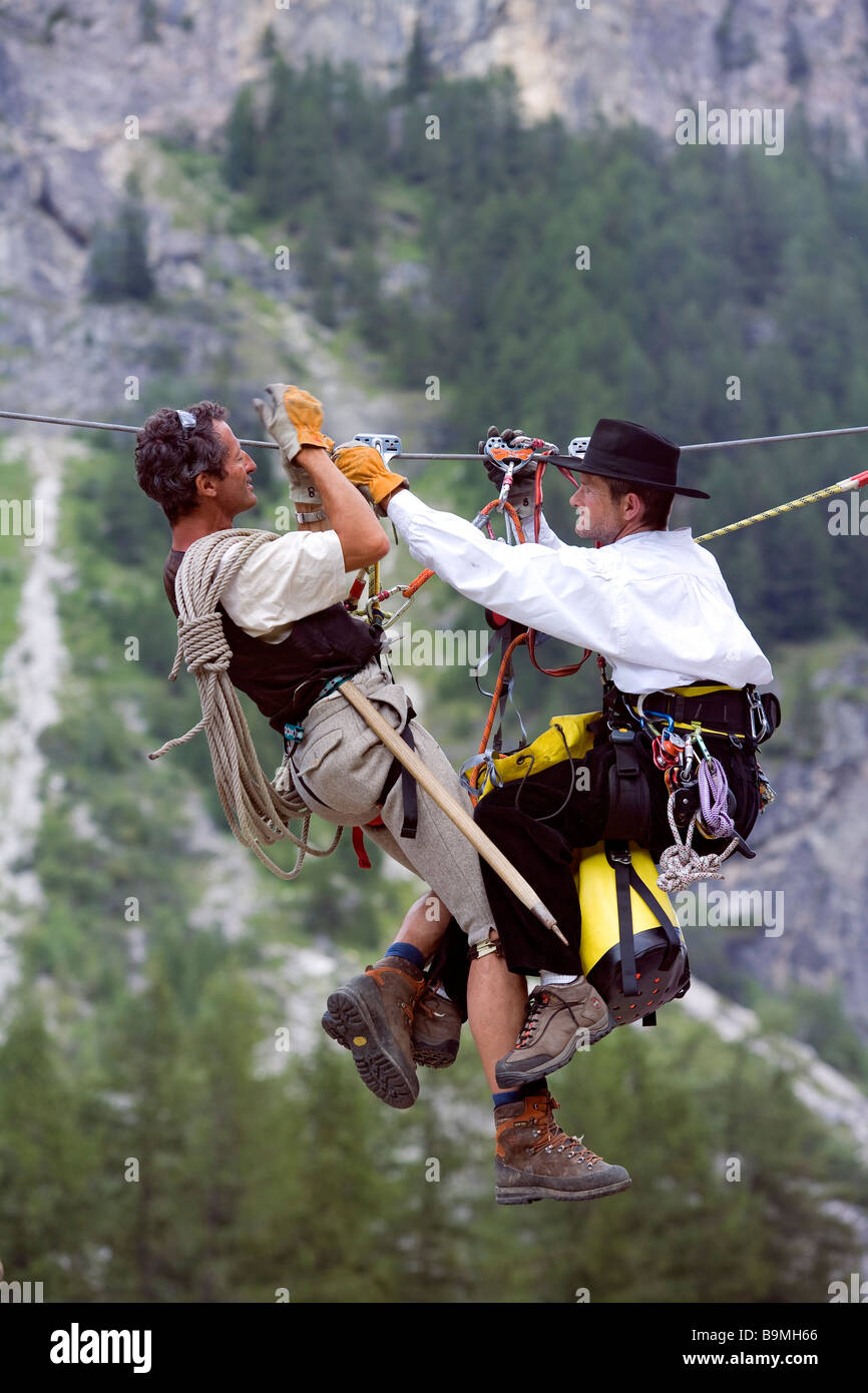 France, Savoie, Peisey Nancroix, Costume et Mountain festival, les hommes sur une tyrolienne crossing Banque D'Images