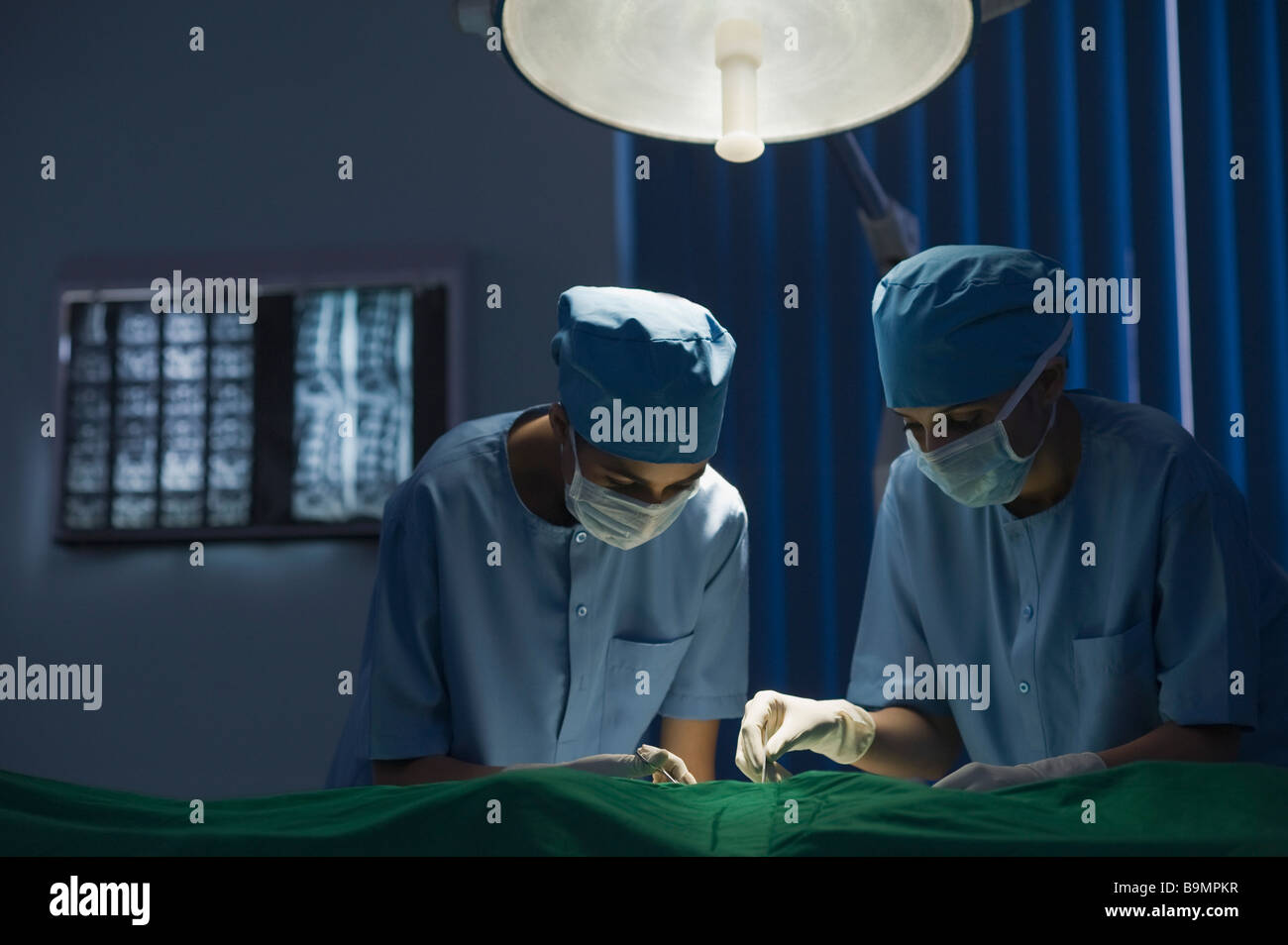 Deux femmes chirurgiens d'effectuer une chirurgie dans une salle d'opération Banque D'Images