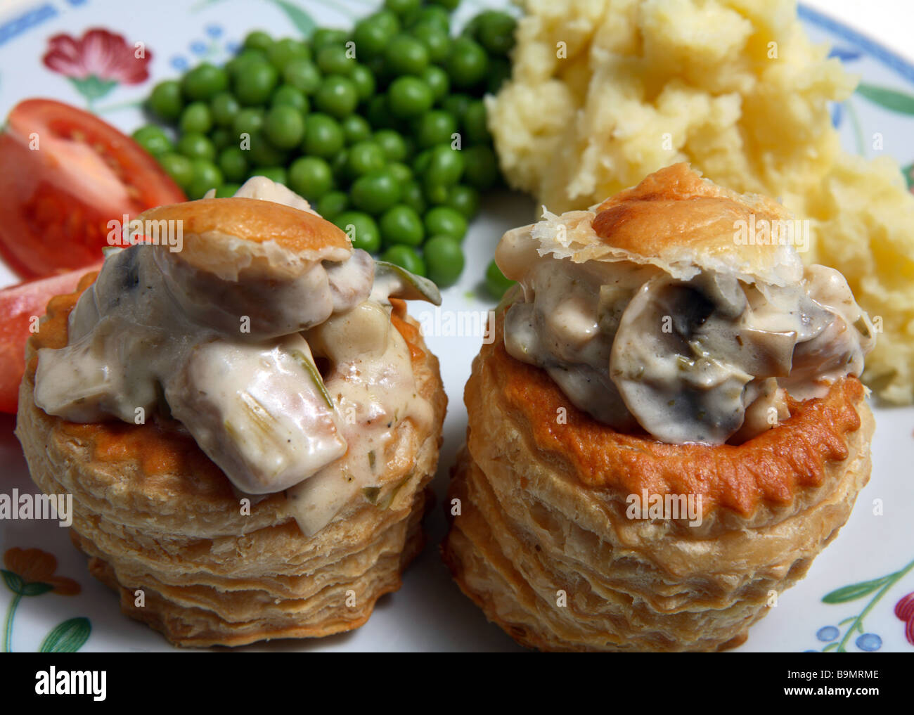 Un dîner de poulet et champignons remplis le vol-au-vents avec des pommes de terre,les petits pois et la tomate. Banque D'Images