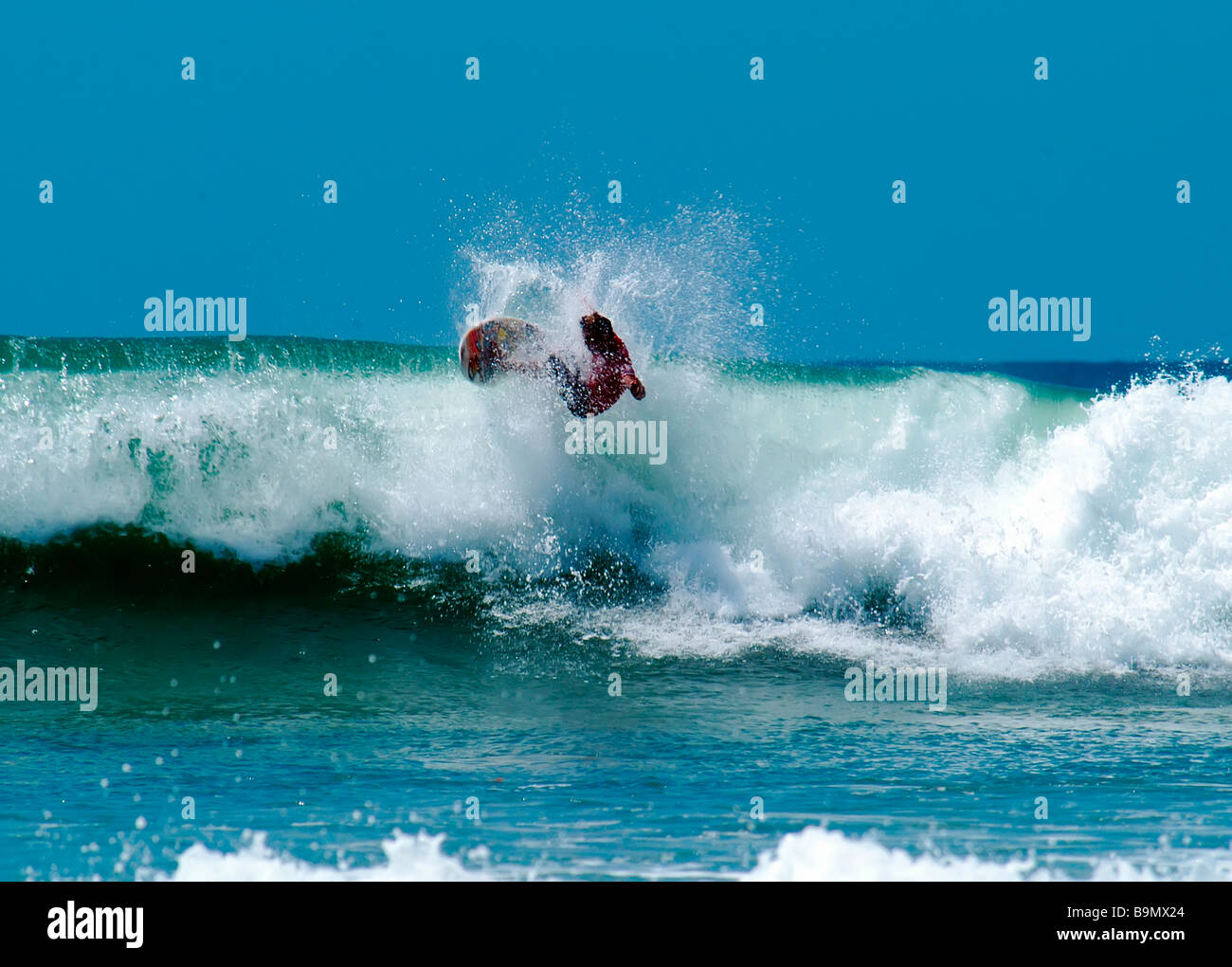 Surfer se tord la mi-air, mais perd la bataille pour rester sur la carte Banque D'Images