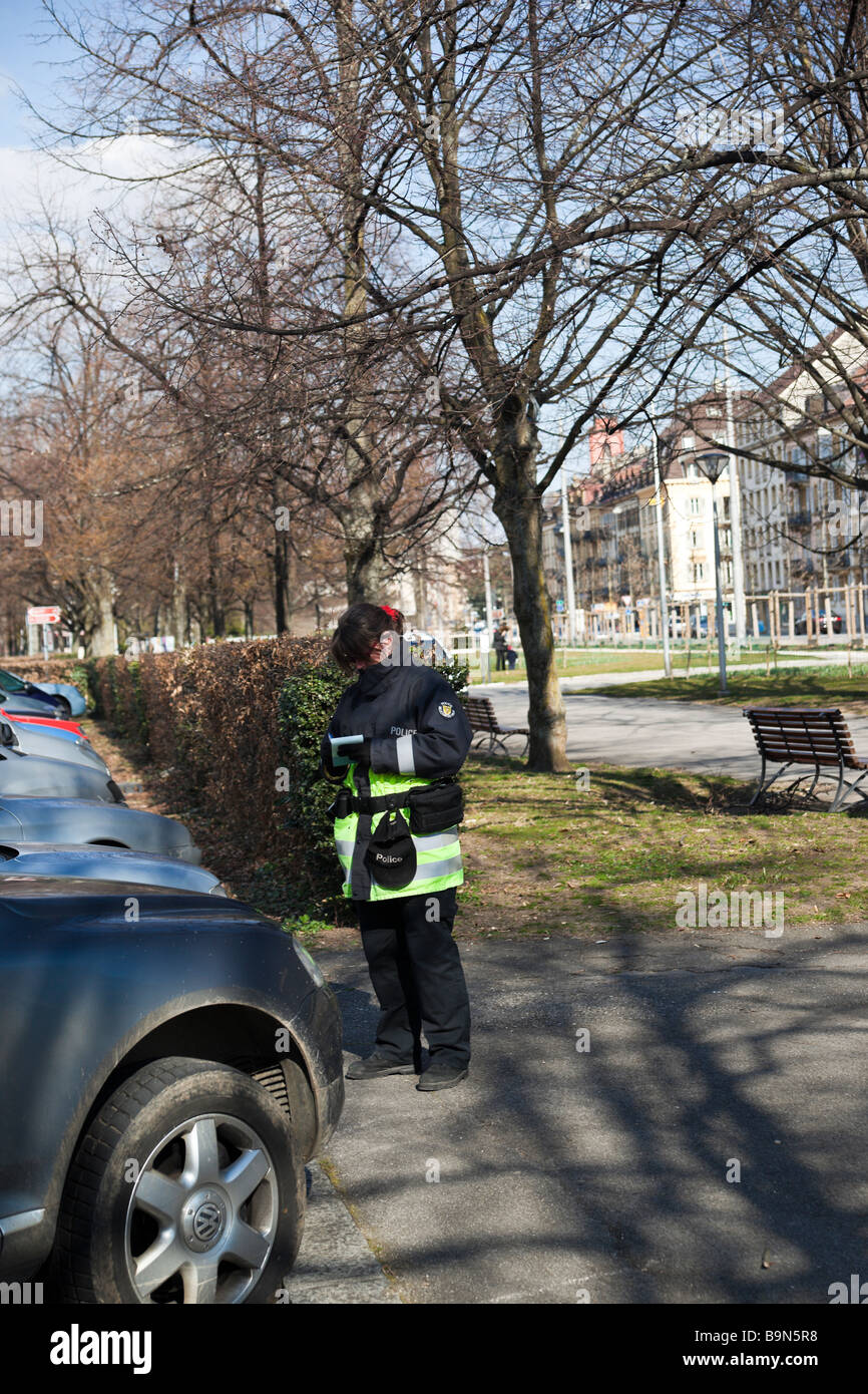 Policewoman wrting un ticket de parking Banque D'Images