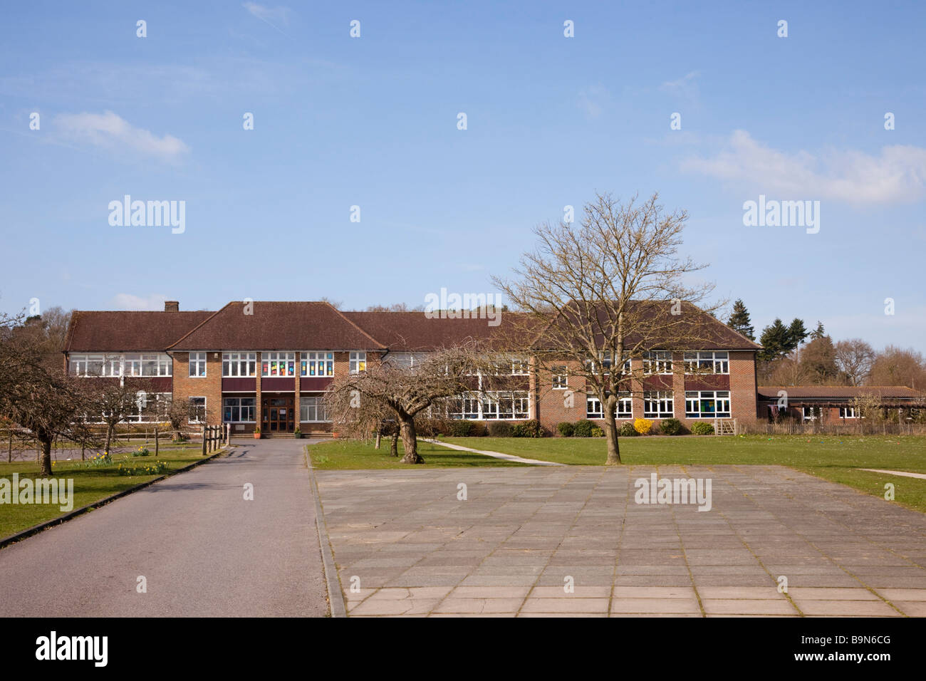 Façade du bâtiment de l'école primaire moderne de l'église d'Angleterre, extérieur et terrain avec longue allée. Tilford Surrey Angleterre Royaume-Uni Banque D'Images
