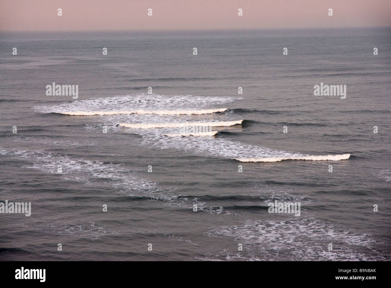 Petites vagues se brisant sur la marée du soir Banque D'Images