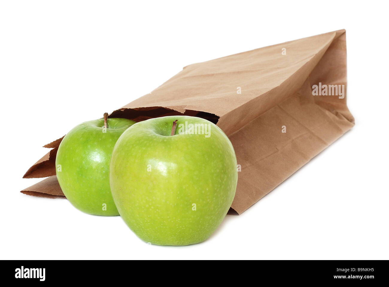 Sac en papier brun avec des pommes vertes sur fond blanc Banque D'Images