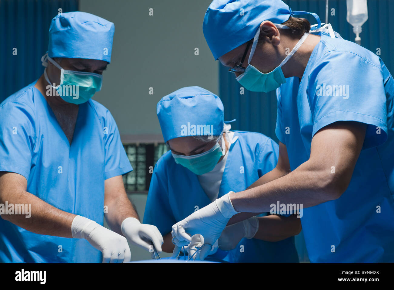 Trois chirurgiens d'effectuer une chirurgie dans une salle d'opération Banque D'Images