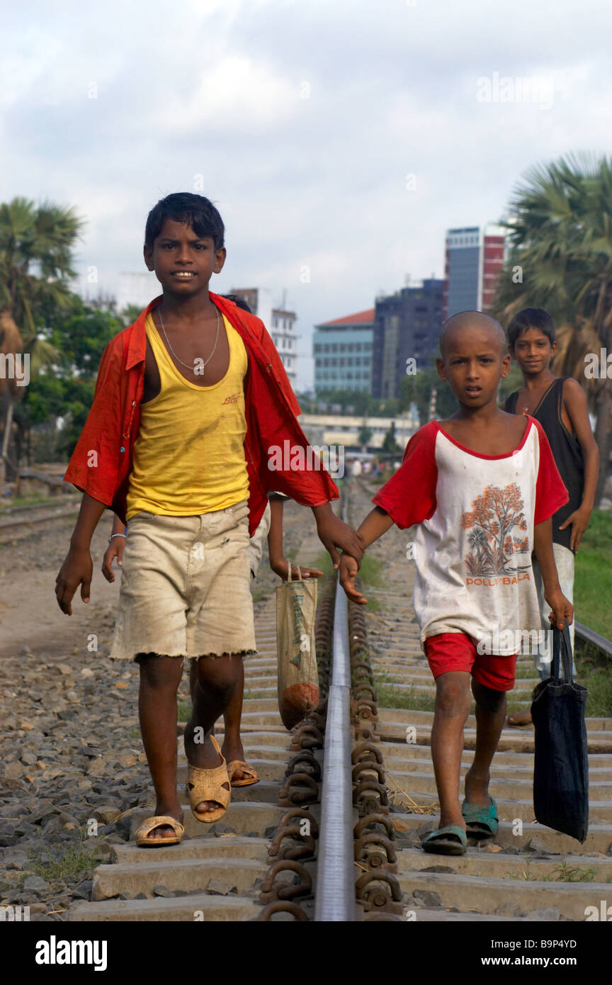 Les garçons à pied d'une voie de chemin de fer tenir la main la pauvreté La pauvreté Banque D'Images