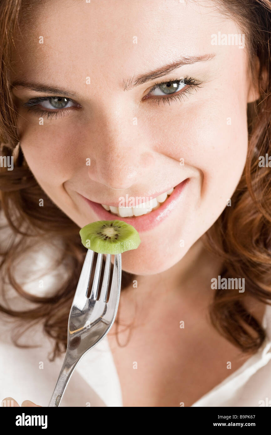 Belle femme manger kiwi Banque D'Images