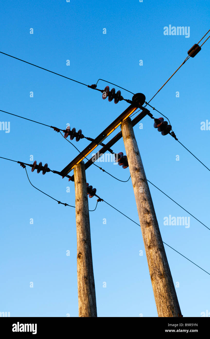 Les câbles et les pylônes d'électricité contre un ciel bleu clair Banque D'Images