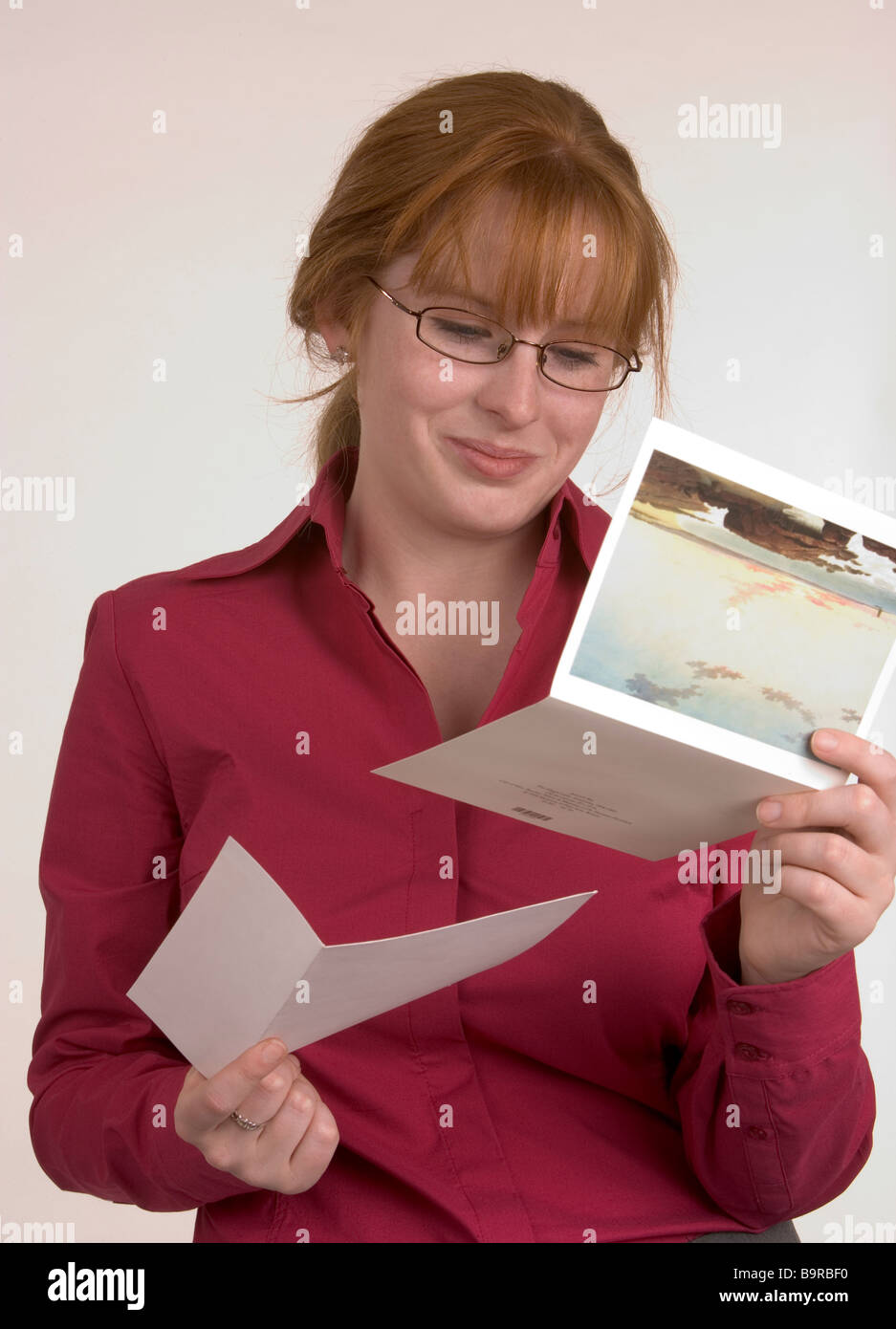 Une femme lisant une carte qui a fait part de certains professionnels news qui a fait de son sourire Banque D'Images