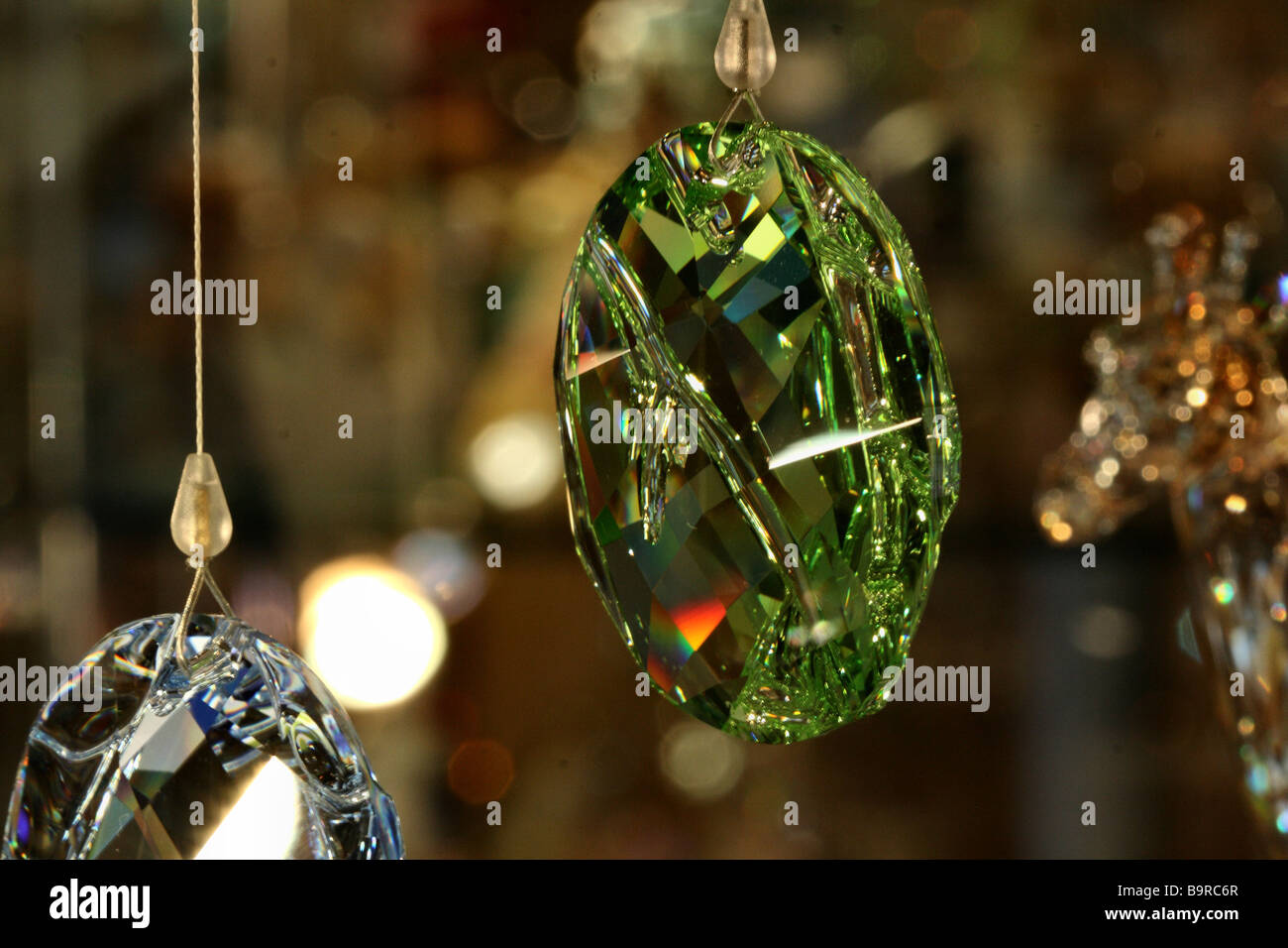 Un cristal vert fascetted relects multi pendentif la lumière en plusieurs couleurs à partir de sa surface à la lumière étincelante Banque D'Images